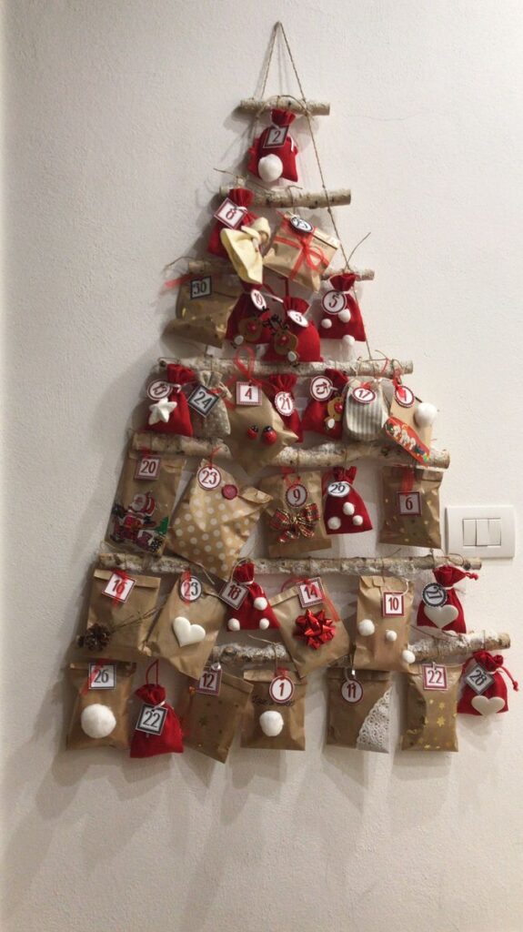 _ 3 DIY hanging Advent calendar with numbered gift bags in a Christmas tree shape on a wall. | Sky Rye Design DIY hanging Advent calendar with numbered gift bags in a Christmas tree shape on a wall.