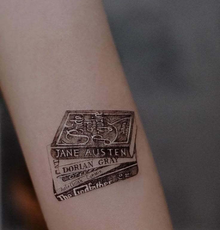 _ 3 Tattoo of classic book spines including Jane Austen and Dorian Gray on a forearm. | Sky Rye Design Tattoo of classic book spines including Jane Austen and Dorian Gray on a forearm.