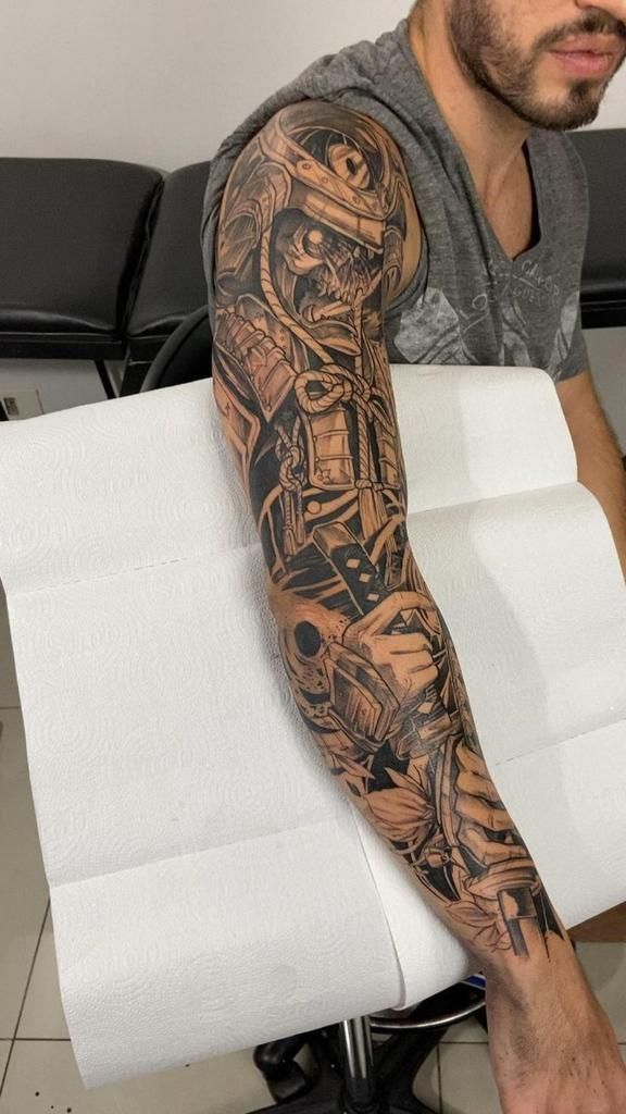 Detailed biomechanical full sleeve tattoo on a person's arm, showcasing intricate design and shading.
