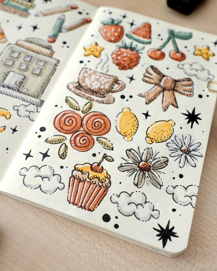 Hand-drawn doodles in a notebook featuring food, flowers, and stars, including strawberries, cupcakes, lemons, and daisies.