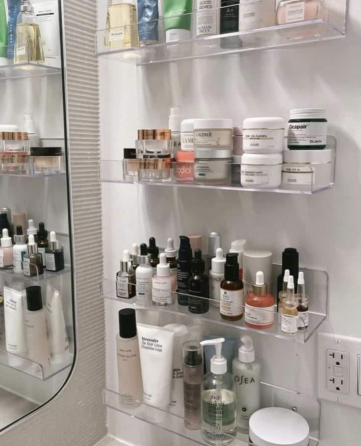 _ 35 Organized skincare products displayed on clear shelves in a bathroom, featuring creams, serums, and lotions. | Sky Rye Design Organized skincare products displayed on clear shelves in a bathroom, featuring creams, serums, and lotions.