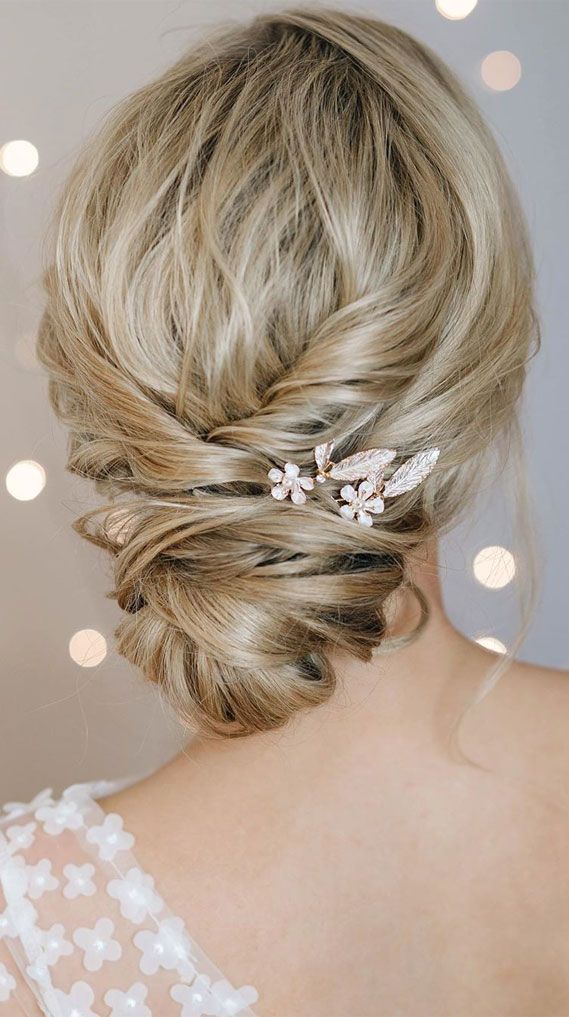 Elegant bridal updo with blonde hair, adorned with floral hairpins, perfect for weddings and special occasions. wedding