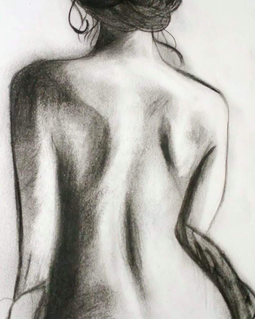 Charcoal drawing of a woman's back, showcasing detailed shading and soft lines, emphasizing form and texture.