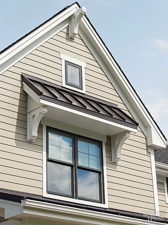 _ 4 Gable roof with modern double window and elegant bracketed awning on beige house exterior against blue sky. | Sky Rye Design Gable roof with modern double window and elegant bracketed awning on beige house exterior against blue sky.