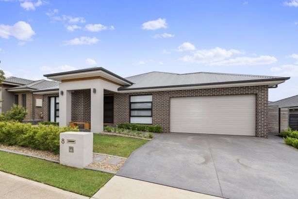 _ 4 Modern single-story brick house with a double garage and well-maintained lawn under a clear blue sky. | Sky Rye Design Modern single-story brick house with a double garage and well-maintained lawn under a clear blue sky.