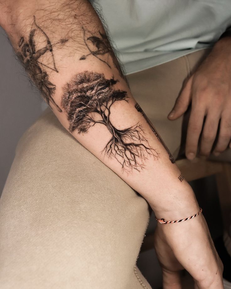 Tattoo of a tree with detailed roots and branches on a person's arm, showcasing artistic body art. tree tattoo