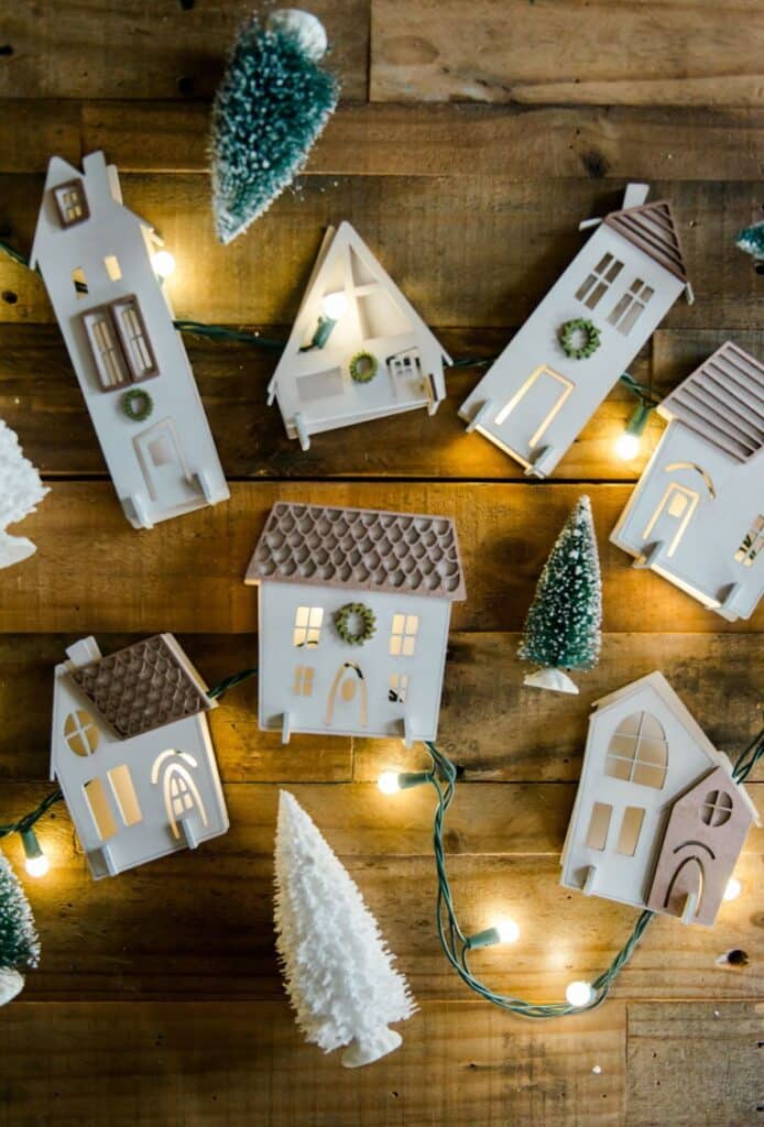 44a9834d3d2ba5503f041ede37c689c4 Miniature wooden houses and Christmas trees with fairy lights on a rustic wooden background. | Sky Rye Design Miniature wooden houses and Christmas trees with fairy lights on a rustic wooden background.