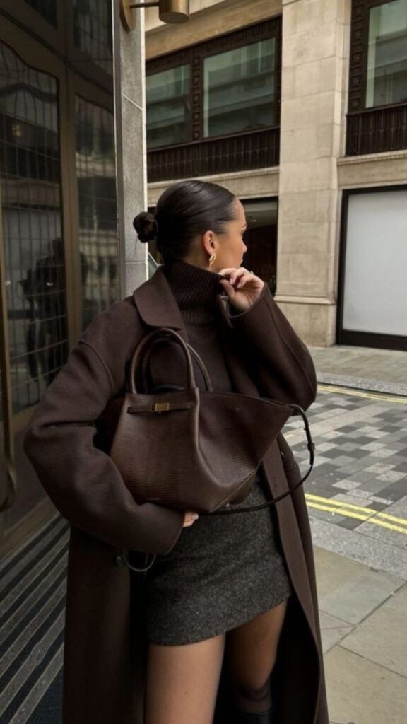 Stylish woman in brown coat with dark bag, city streetscape background. Urban fashion concept.
Outfit Ideas for Autumn