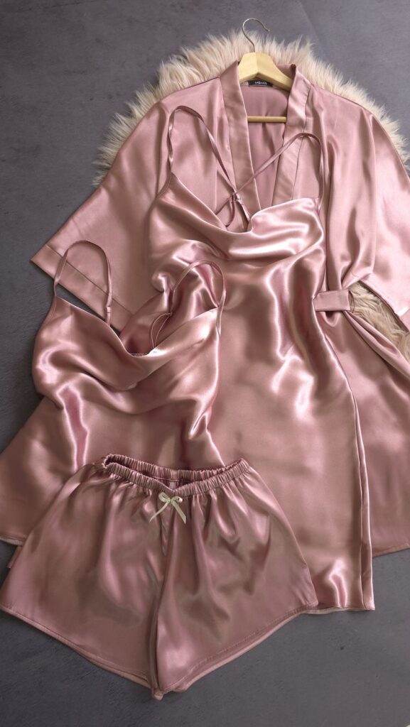 Pink satin pajama set with robe and shorts on a hanger with fur detailing, ideal for cozy nights.
