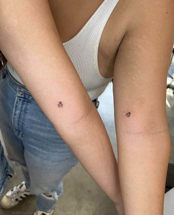 _ 5 Matching small ladybug tattoos on two people's forearms, close-up view. | Sky Rye Design Matching small ladybug tattoos on two people's forearms, close-up view.