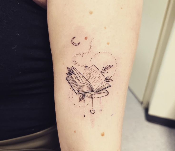 _ 5 Minimalist tattoo of an open book with stars, crescent moon, and heart on upper arm. | Sky Rye Design Minimalist tattoo of an open book with stars, crescent moon, and heart on upper arm.