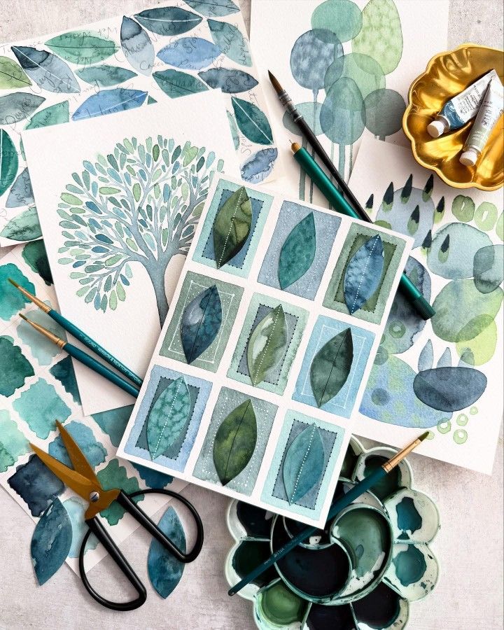 Watercolor artworks with leaf and tree designs, paintbrushes, scissors, and a palette in green and blue hues.