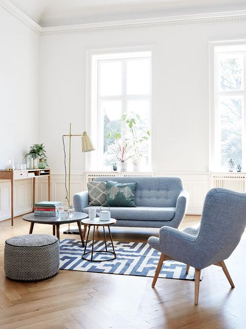 _ 5 Modern living room with blue furniture, geometric rug, and natural light from large windows. Cozy and stylish decor. | Sky Rye Design Modern living room with blue furniture, geometric rug, and natural light from large windows. Cozy and stylish decor.