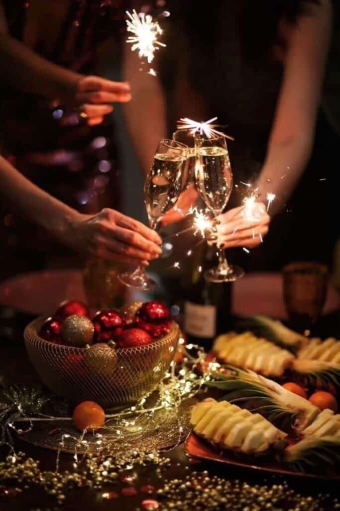 Festive celebration with sparkling champagne, sparklers, and holiday decorations on a table setting.