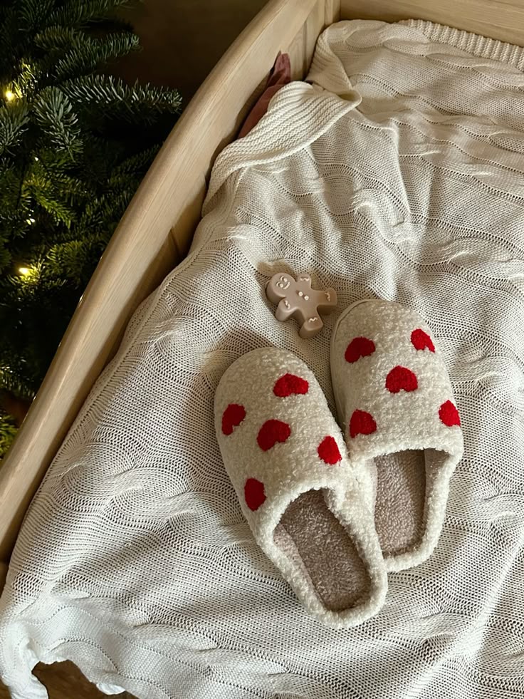 512352b98695ed2b03c1a3d0eb466ab7 Cozy holiday scene: fuzzy heart slippers and gingerbread ornament on cream knit blanket by Christmas tree. | Sky Rye Design Cozy holiday scene: fuzzy heart slippers and gingerbread ornament on cream knit blanket by Christmas tree.