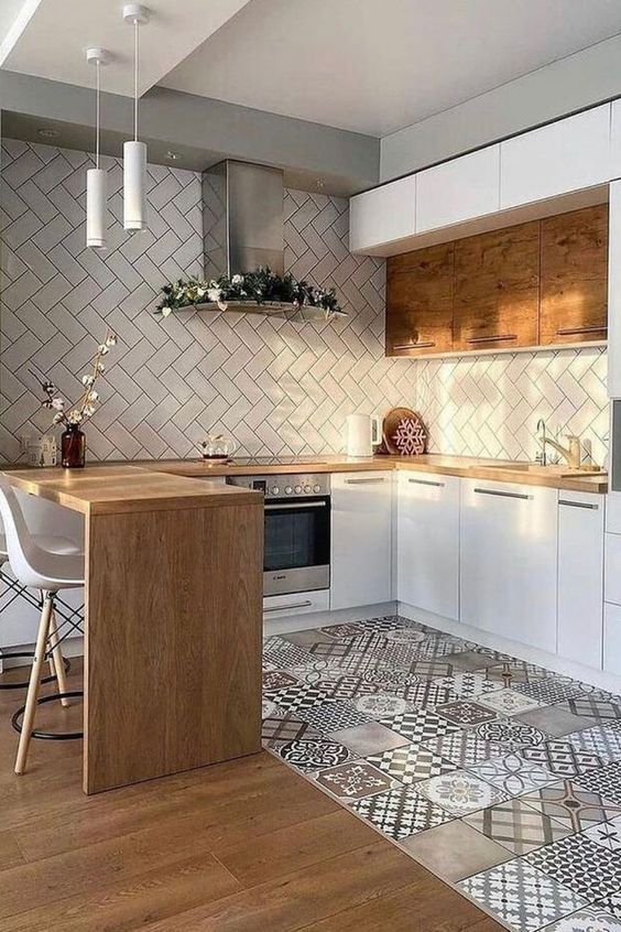 Modern kitchen with herringbone tile backsplash, wood countertops, and patterned floor tiles. Cozy and stylish design.