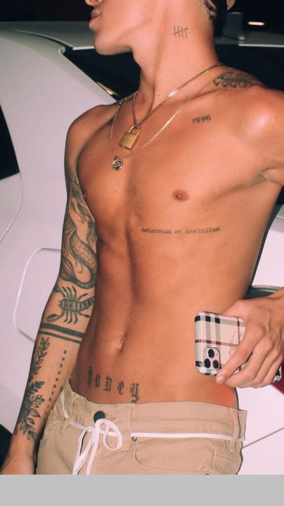 57114f93d9233b0d5a13a77cdb3110ec Shirtless person with tattoos holds a smartphone, showcasing body art and casual style. | Sky Rye Design Shirtless person with tattoos holds a smartphone, showcasing body art and casual style.