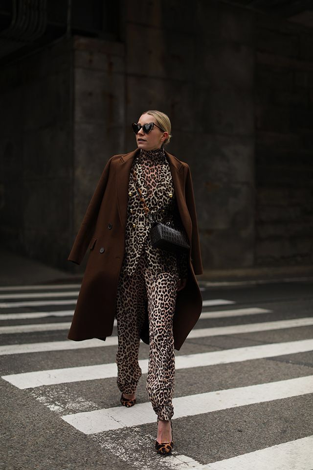 _ 6 Stylish woman in leopard print outfit and brown coat crossing a street, wearing sunglasses and holding a black bag. | Sky Rye Design Stylish woman in leopard print outfit and brown coat crossing a street, wearing sunglasses and holding a black bag.