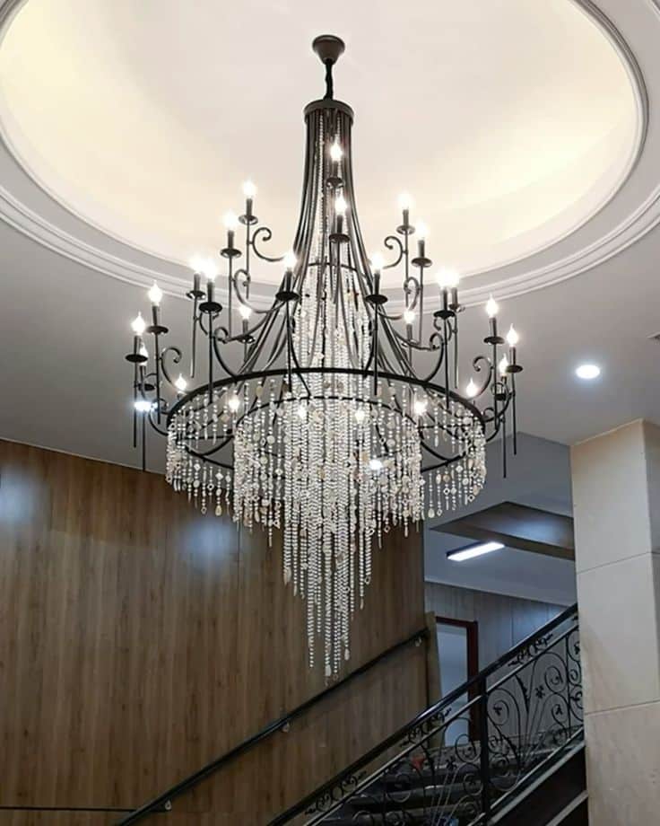 Elegant crystal chandelier hanging in a modern staircase, creating a luxurious and sophisticated ambiance.