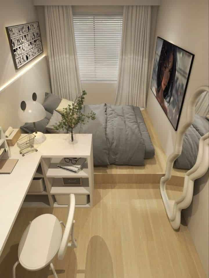 Modern small bedroom with a cozy bed, desk, large mirror, and wall art. Simple decor and soft lighting create a serene atmosphere.