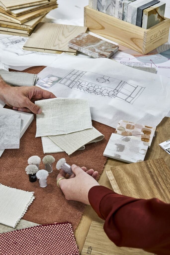 66c9ce4a8401d0c76de7778f28b057eb Interior design materials and fabric swatches on a table, hands selecting samples for a project. | Sky Rye Design Interior design materials and fabric swatches on a table, hands selecting samples for a project.