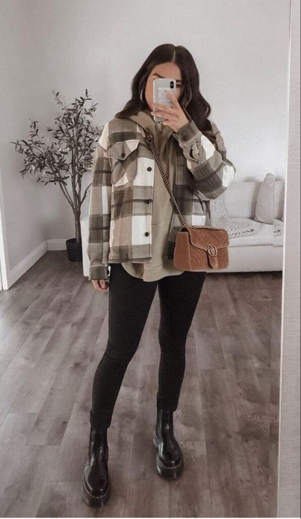 6afb609f-763d-4417-b37c-43e5ba5f4ad2 Woman in plaid jacket with crossbody bag takes mirror selfie in stylish outfit. | Sky Rye Design Woman in plaid jacket with crossbody bag takes mirror selfie in stylish outfit.