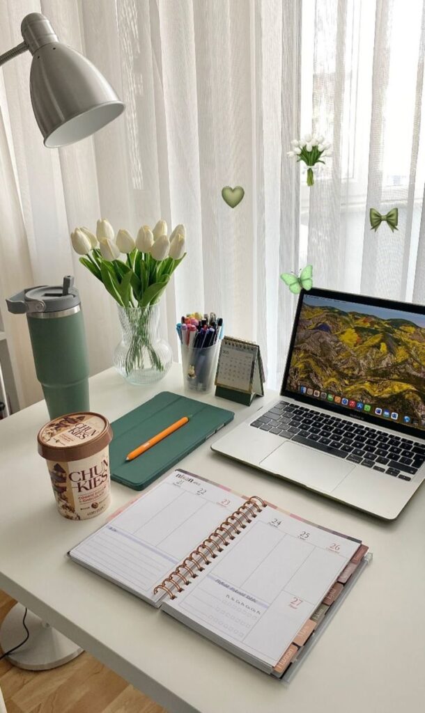83e1c32a-5df0-4eb9-bf4c-3658bda8795a Cozy home office setup with laptop, planner, and flowers on a desk for productive workspace inspiration. | Sky Rye Design Cozy home office setup with laptop, planner, and flowers on a desk for productive workspace inspiration.