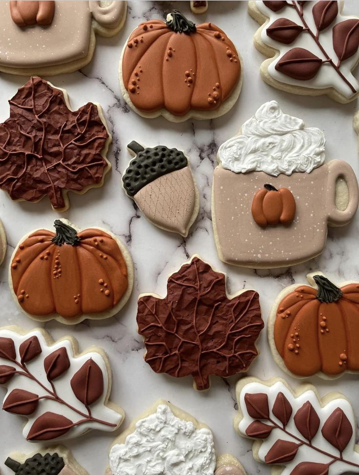 888a9d77-94b2-4fca-91c0-321db6140875 Fall-themed cookies with pumpkins, leaves, acorns, and a cup with whipped cream on marble background. | Sky Rye Design Fall-themed cookies with pumpkins, leaves, acorns, and a cup with whipped cream on marble background.