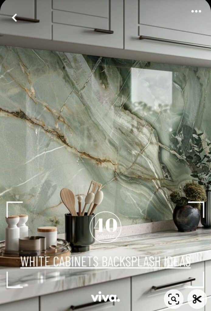 Elegant kitchen with marble backsplash and white cabinets, featuring wooden utensils and modern decor accents.