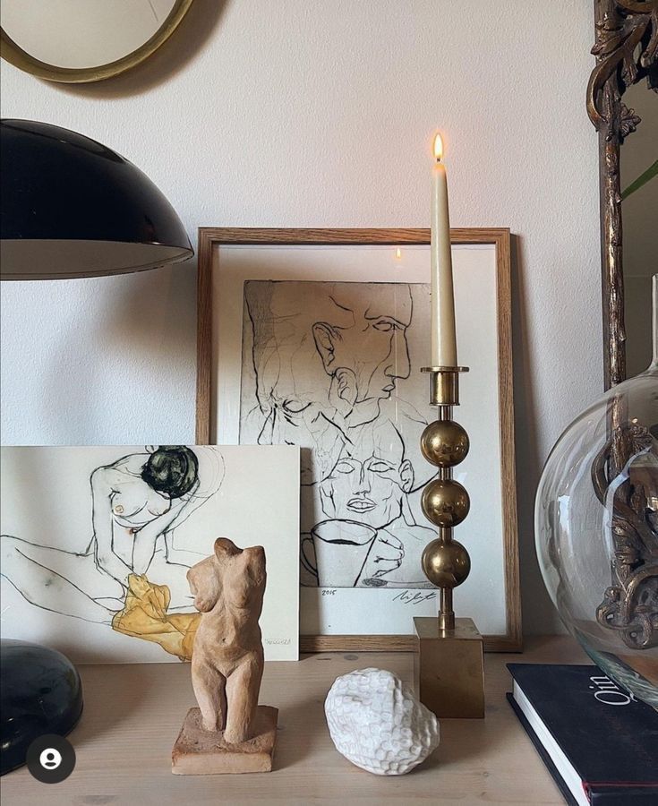 _ 9 Artistic desk setup with framed sketches, a sculpted torso, a decorative candle holder, and books for a cozy aesthetic. | Sky Rye Design Artistic desk setup with framed sketches, a sculpted torso, a decorative candle holder, and books for a cozy aesthetic.