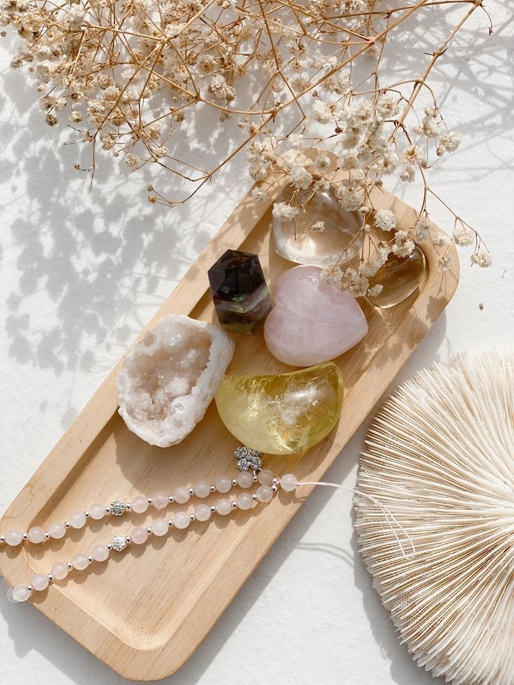 Tray with healing crystals, dried flowers, and beads, creating a serene, natural setting. Perfect for meditation or decor.
