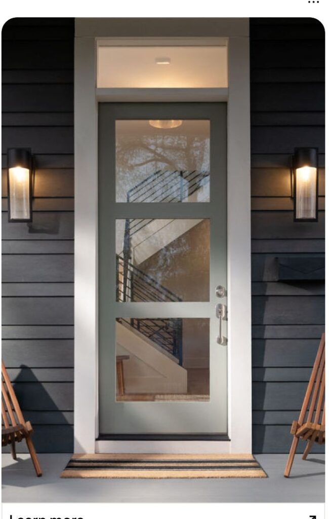 _ 9 Modern front door with glass panels and side lights, black siding, and outdoor wall sconces at entrance. | Sky Rye Design Modern front door with glass panels and side lights, black siding, and outdoor wall sconces at entrance.