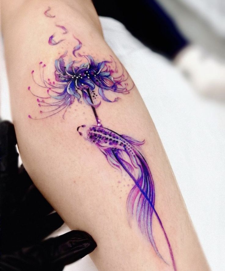 963ec788-1912-4ae5-bf79-4db3413c555d Colorful tattoo of a fish and flower in vibrant purples and blues on an arm, showcasing intricate details and artistry. | Sky Rye Design Colorful tattoo of a fish and flower in vibrant purples and blues on an arm, showcasing intricate details and artistry.