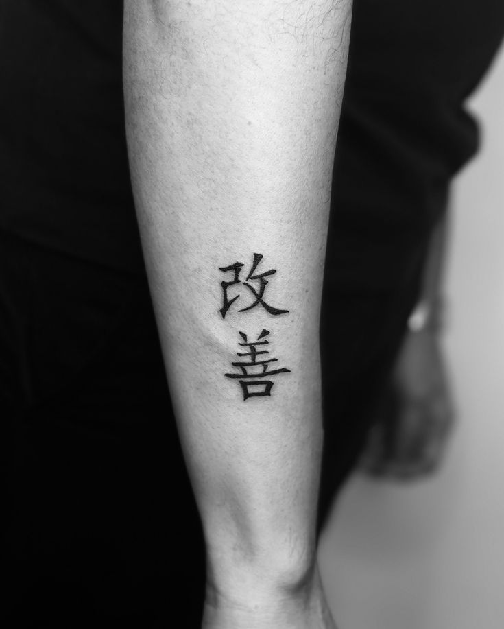 A Kaizen tattoo represents the Japanese philosophy Forearm tattoo with Japanese kanji characters in black ink, elegantly displayed on light skin. | Sky Rye Design Forearm tattoo with Japanese kanji characters in black ink, elegantly displayed on light skin.