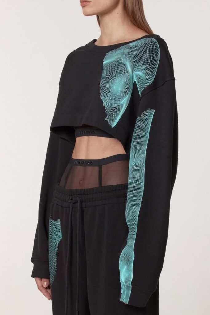 AI MET A WOMAN Woman wearing black streetwear with teal digital print design, sheer panels, and drawstring pants. | Sky Rye Design Woman wearing black streetwear with teal digital print design, sheer panels, and drawstring pants.