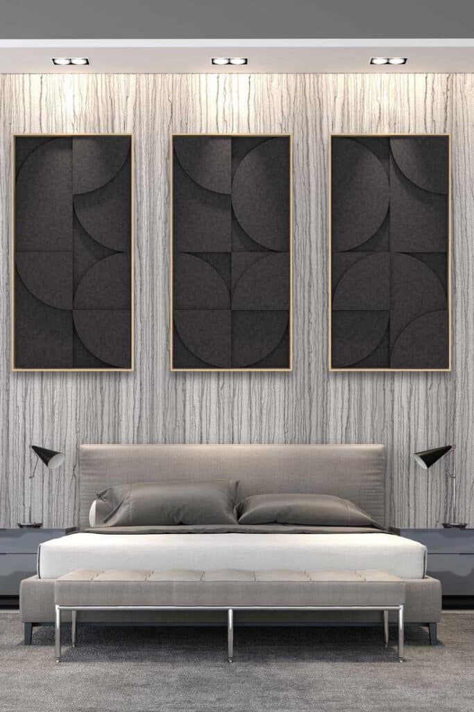 Modern bedroom with geometric art panels, gray bed, and stylish lamps on a textured wall background.