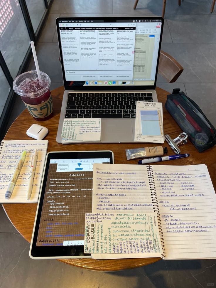 Aesthetic Study Motivation 2 Study setup with laptop, tablet, notes, pens, and a beverage on a round table in a cafe. | Sky Rye Design Study setup with laptop, tablet, notes, pens, and a beverage on a round table in a cafe.