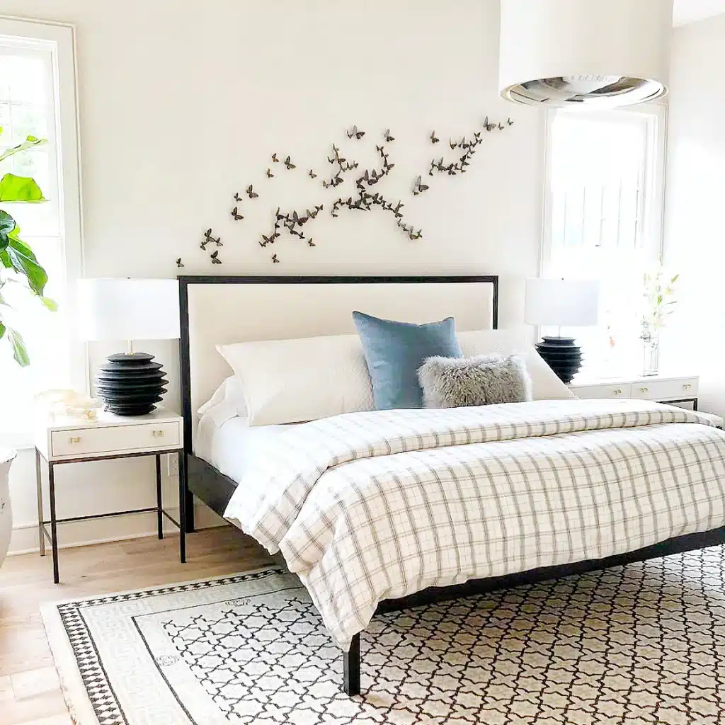 BF-wall-above-bed Modern bedroom with stylish bed, decorative pillows, and butterfly wall art for a serene and elegant atmosphere. | Sky Rye Design Modern bedroom with stylish bed, decorative pillows, and butterfly wall art for a serene and elegant atmosphere.