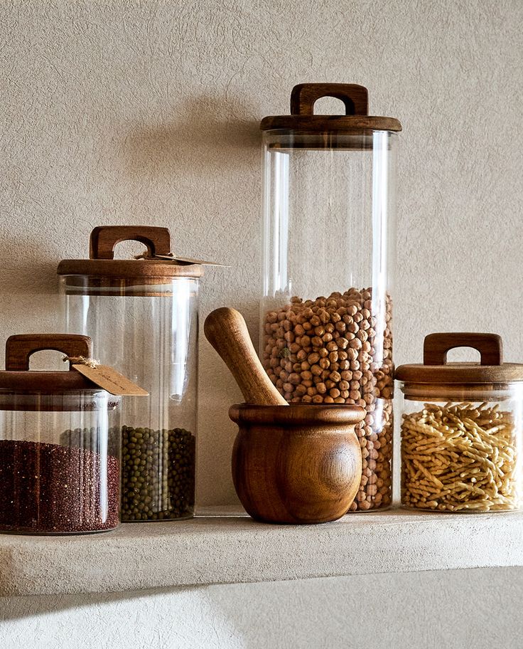 BOROSILICATE GLASS AND WOOD STORAGE JAR _ Zara Home United States of America Glass jars with wooden lids store grains and legumes on a kitchen shelf, accompanied by a wooden mortar. | Sky Rye Design Glass jars with wooden lids store grains and legumes on a kitchen shelf, accompanied by a wooden mortar.