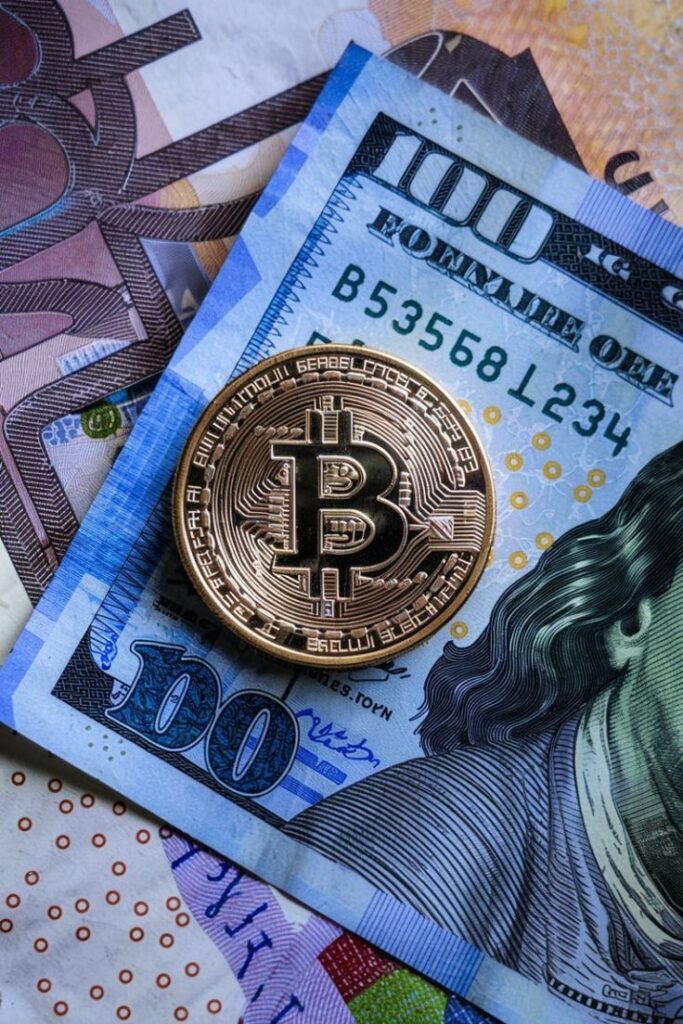 Bitcoin Bitcoin coin on top of 100-dollar and euro notes, symbolizing cryptocurrency and traditional finance integration. | Sky Rye Design Bitcoin coin on top of 100-dollar and euro notes, symbolizing cryptocurrency and traditional finance integration.