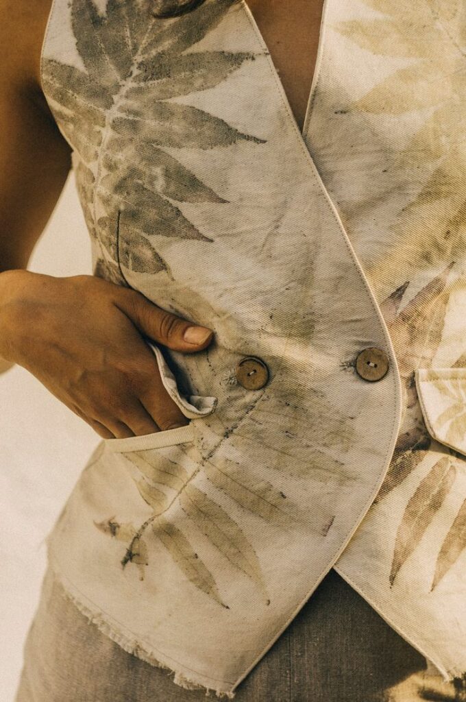 Person wearing a leaf-print vest with hands in pockets, showcasing nature-inspired fashion design.