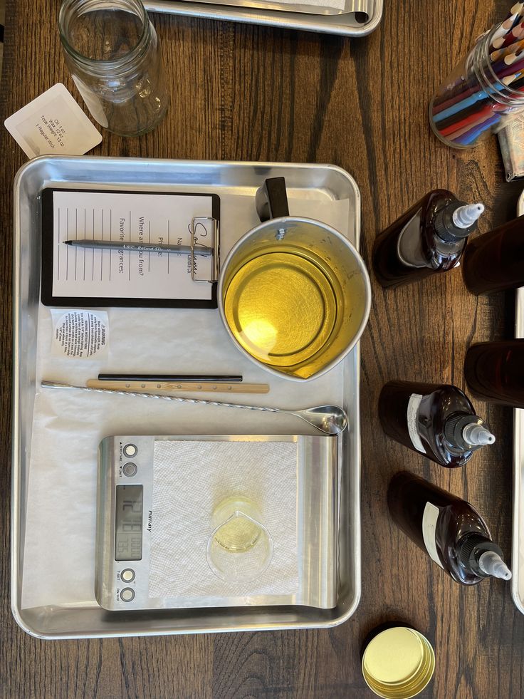 Candle Making Candle making setup with wax, scale, notepad, glass jar, and supplies on a wooden table. | Sky Rye Design Candle making setup with wax, scale, notepad, glass jar, and supplies on a wooden table.