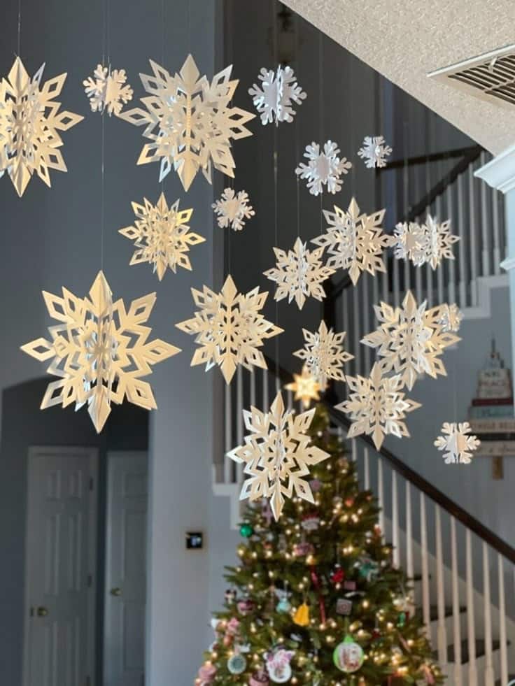 Christmas Hanging Snowflake Decorations White 3d Hanging snowflake decorations with a Christmas tree in a festive living room. | Sky Rye Design Hanging snowflake decorations with a Christmas tree in a festive living room.