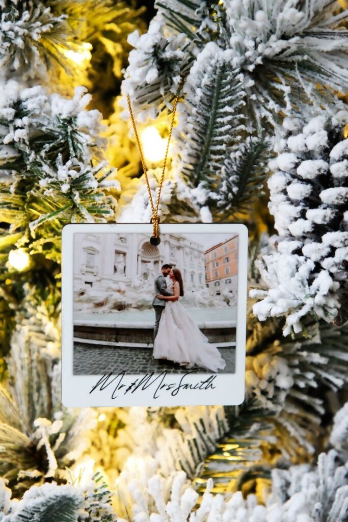 Christmas Ornament with Photo 🎄 Wedding photo ornament hanging on a snowy Christmas tree branch with warm lights. | Sky Rye Design Wedding photo ornament hanging on a snowy Christmas tree branch with warm lights.