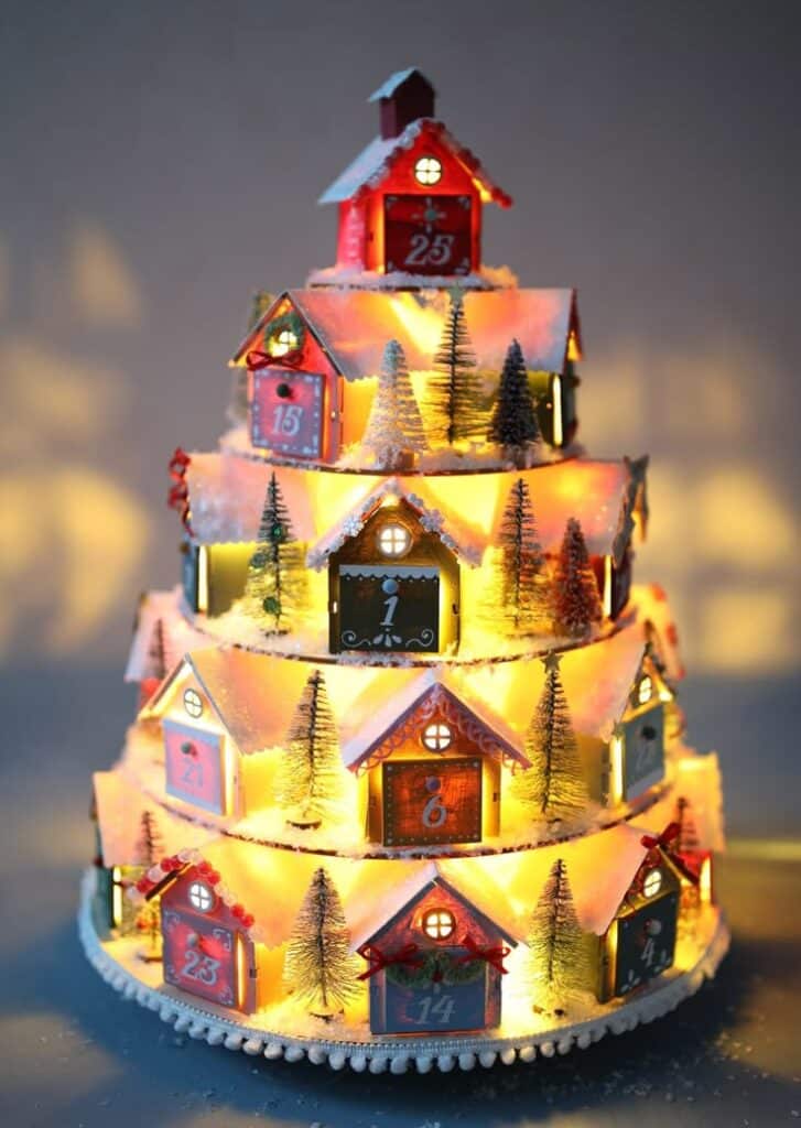 Christmas Village Tiered Advent Calendar Illuminated Christmas advent calendar in tree shape with tiny houses and snowy decorations. | Sky Rye Design Illuminated Christmas advent calendar in tree shape with tiny houses and snowy decorations.
