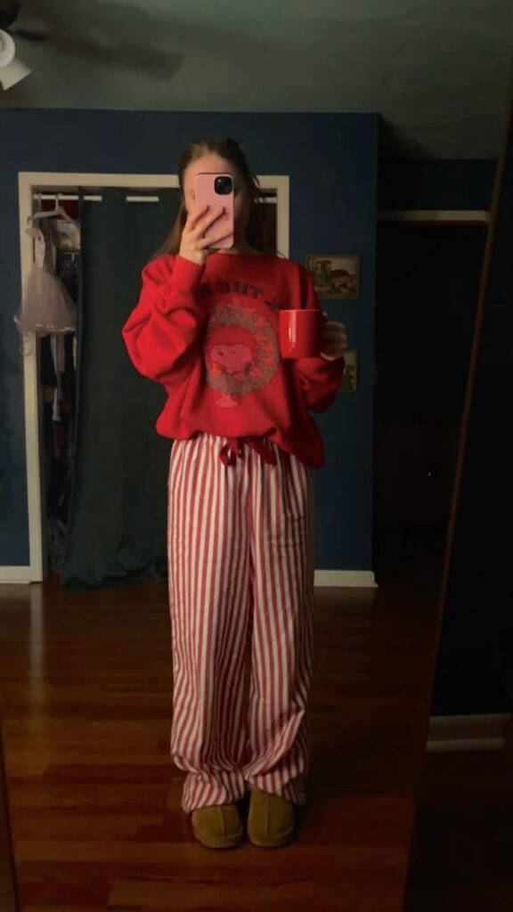 Christmas pajamas Person in cozy red sweatshirt and striped pajama pants holds a red mug in bedroom mirror selfie. | Sky Rye Design Person in cozy red sweatshirt and striped pajama pants holds a red mug in bedroom mirror selfie.