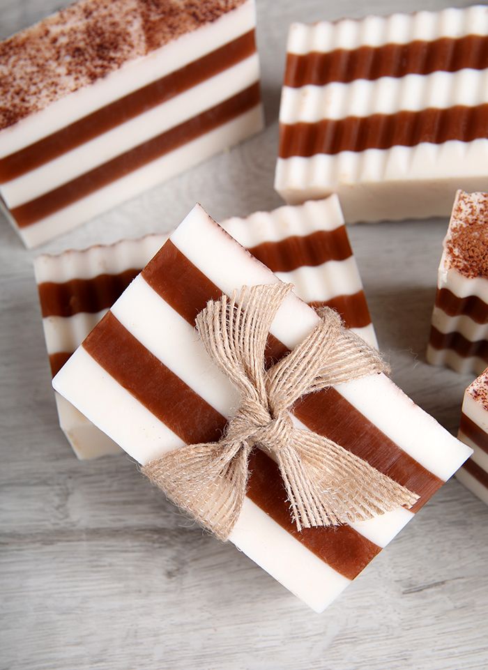 Cinnamon Cocoa Melt Pour Soap Striped artisan soap bars with a burlap bow, featuring white and brown layers on a rustic wooden surface. | Sky Rye Design Striped artisan soap bars with a burlap bow, featuring white and brown layers on a rustic wooden surface.