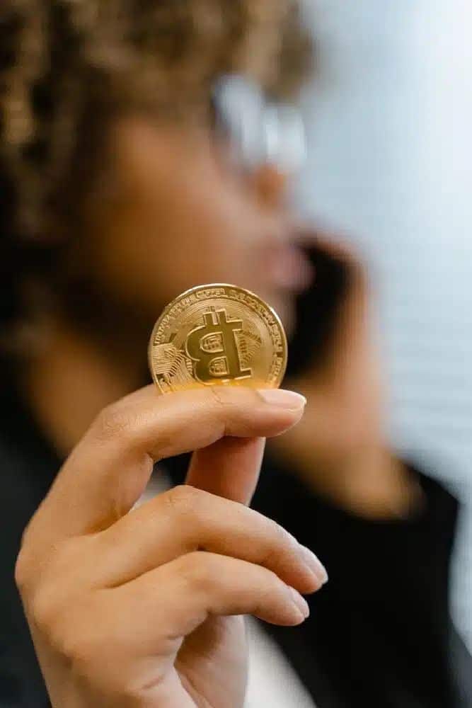 Collaborative Approach With Bitcoin And Blockchain Person holding a Bitcoin coin in focus, suggesting cryptocurrency investment or trading, with blurred background. | Sky Rye Design Person holding a Bitcoin coin in focus, suggesting cryptocurrency investment or trading, with blurred background.
