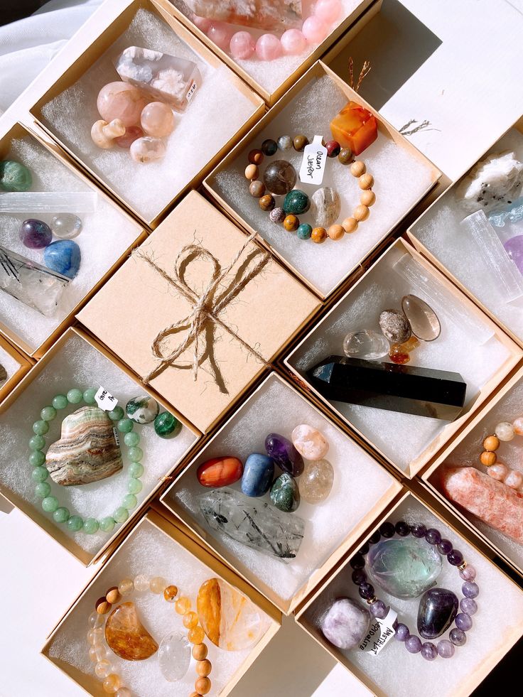 Assorted crystal jewelry in gift boxes, featuring bracelets and stones for healing and positivity. Crystal