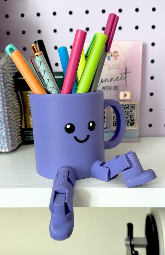 Purple mug with a smiley face and arms holding colorful pens on a shelf.
